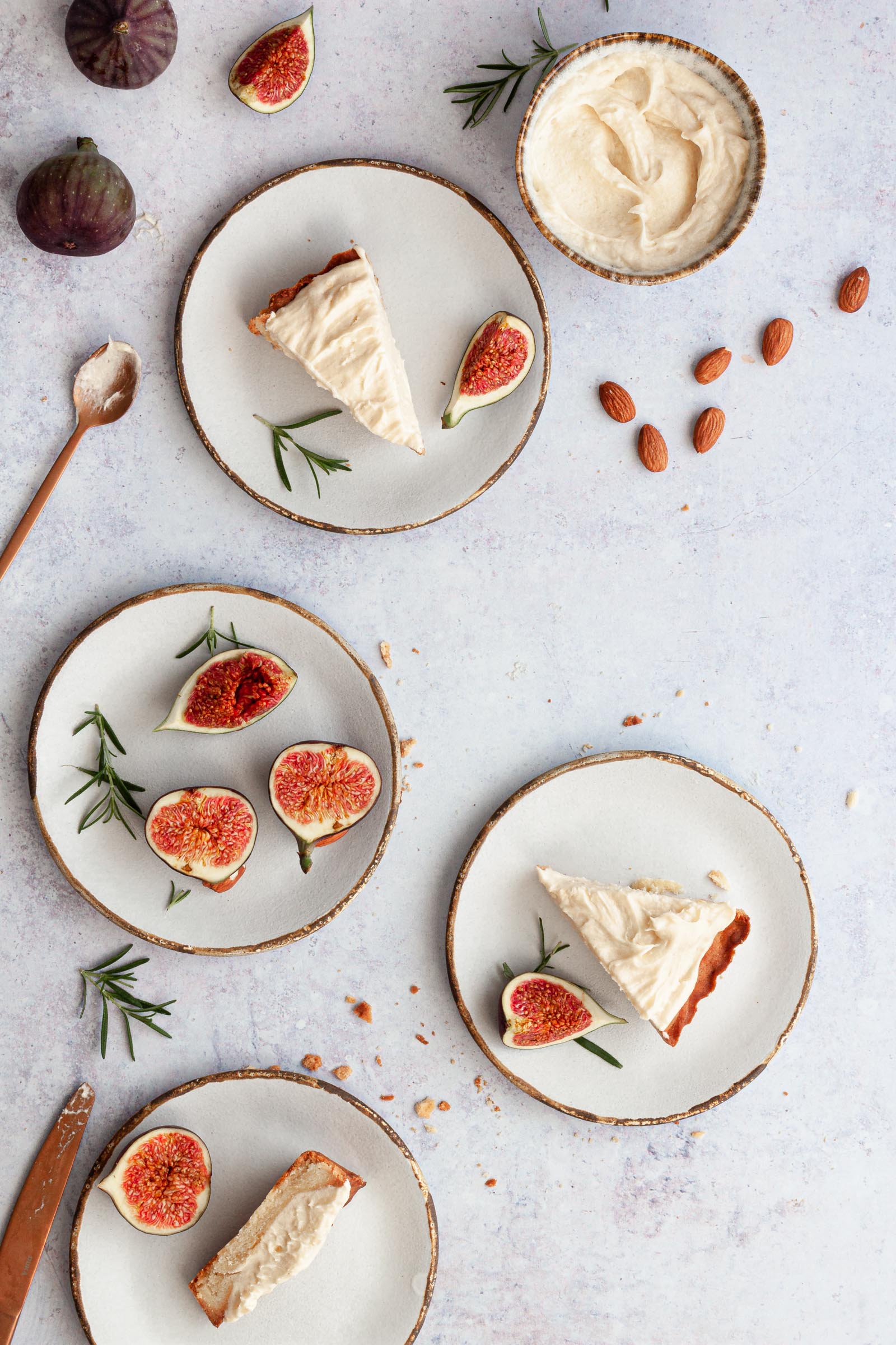 Slices of fig tart on plates, plate with fig pieces and a few almonds on the side.