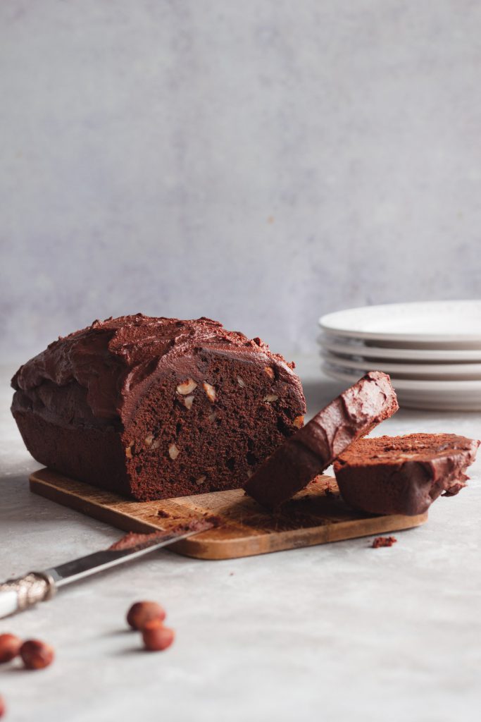 Sliced pieces of the chocolate cake lying on the side, the rest of the cake in the background.