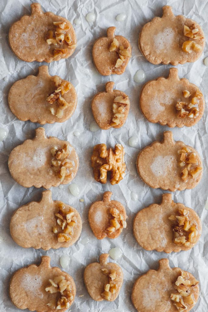 Rows of cinnamon sugar cookies decorated with lemon icing and walnuts.