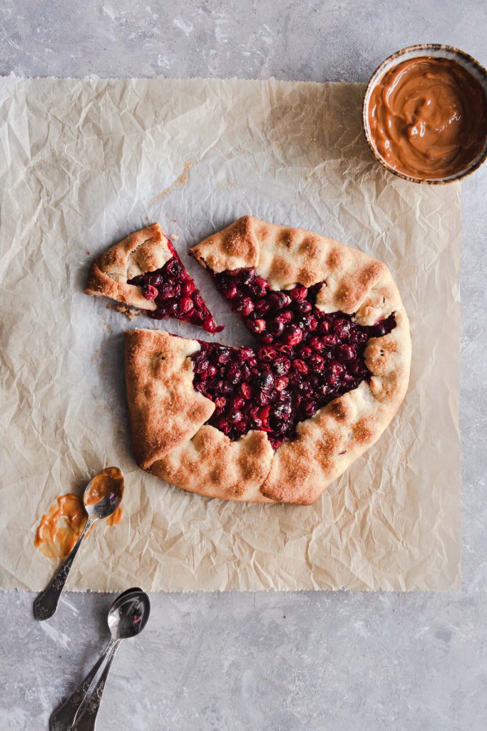 Sliced cranberry galette with dulce de leche on the side.