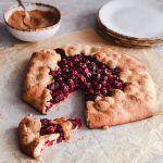 Sliced cranberry galette topped with dulce de leche.