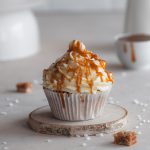 Cupcake decorated with cream cheese frosting and salted caramel.